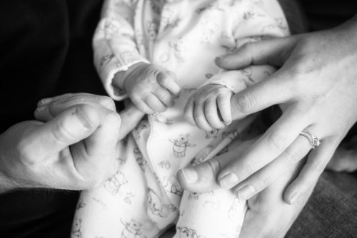 Newborn fingers gripping Mum & Dad photographers in Cockermouth