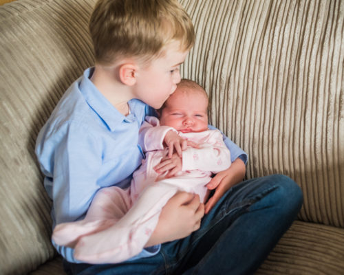 Big brother Riley kissing baby, newborn photographers Gretna