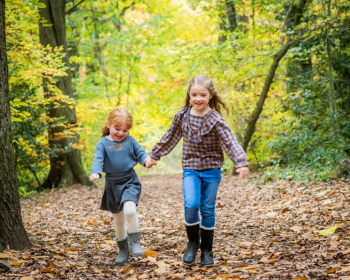 Sisters running in woods, baby photographer Cockermouth