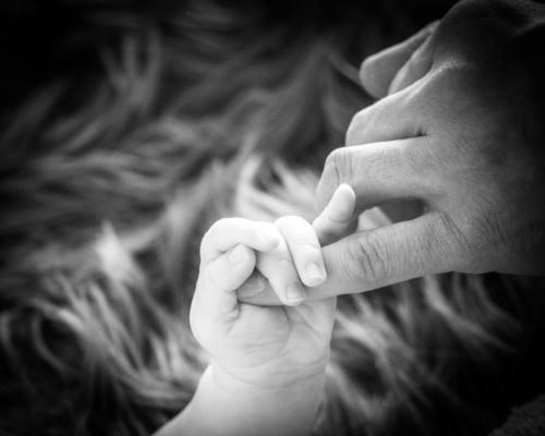 Henry holding his Dad's finger, newborn photographers Cumbria