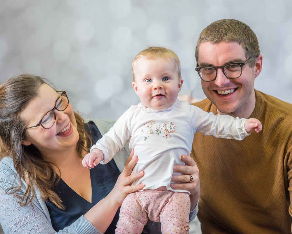 Baby Georgie smiling with her Mum and Dad, Cockermouth baby photographers