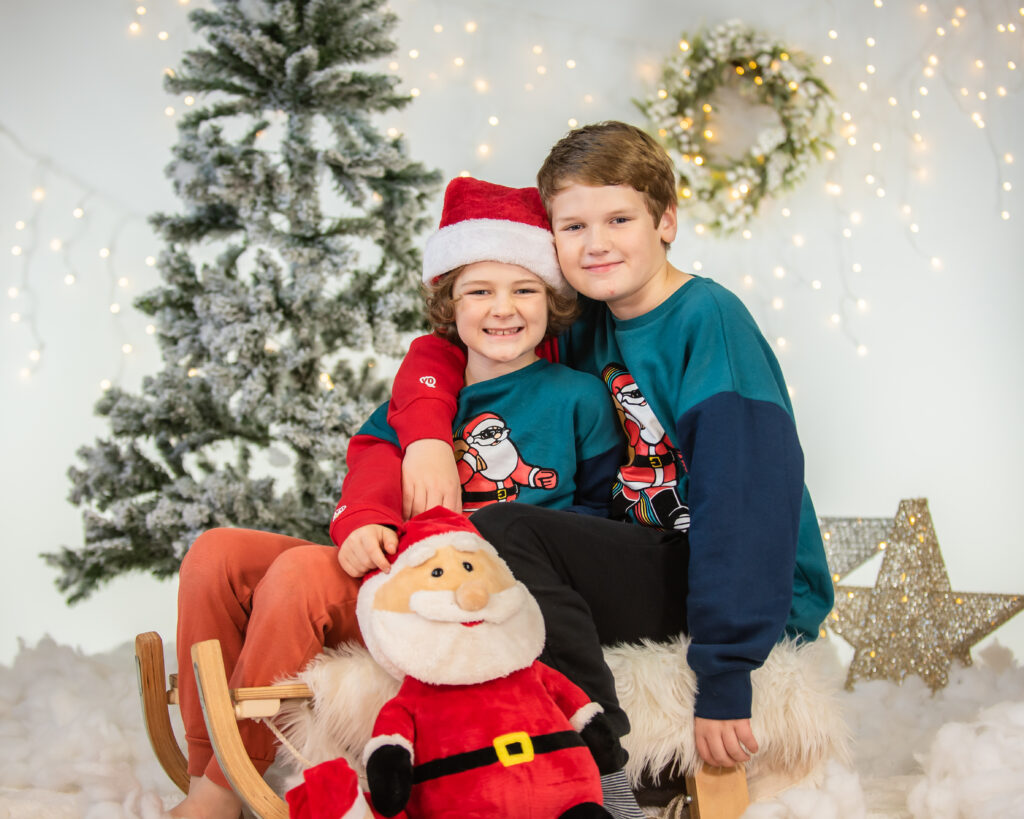 Brothers cuddle on sledge, Christmas minis, Fletchertown photographers Cumbria