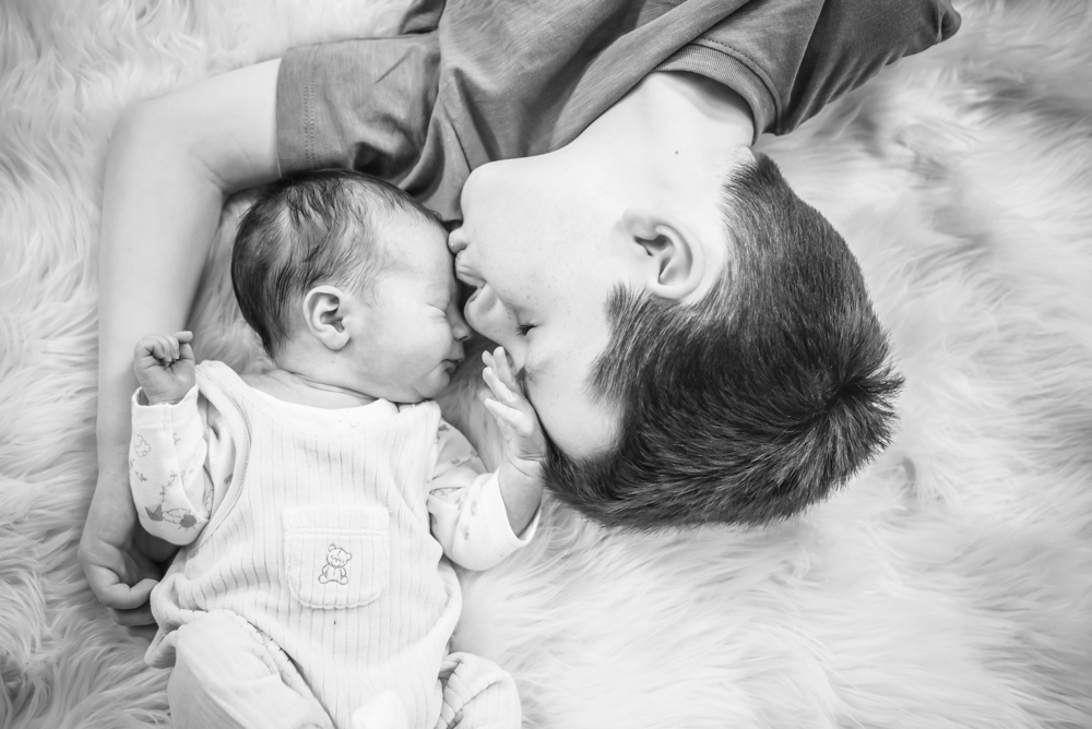 Big brother Milo kisses baby brother, newborn photographer Cockermouth
