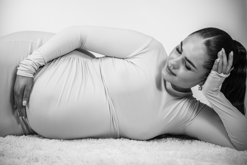 Nicole lying down cradling bump, Carlisle maternity photographers