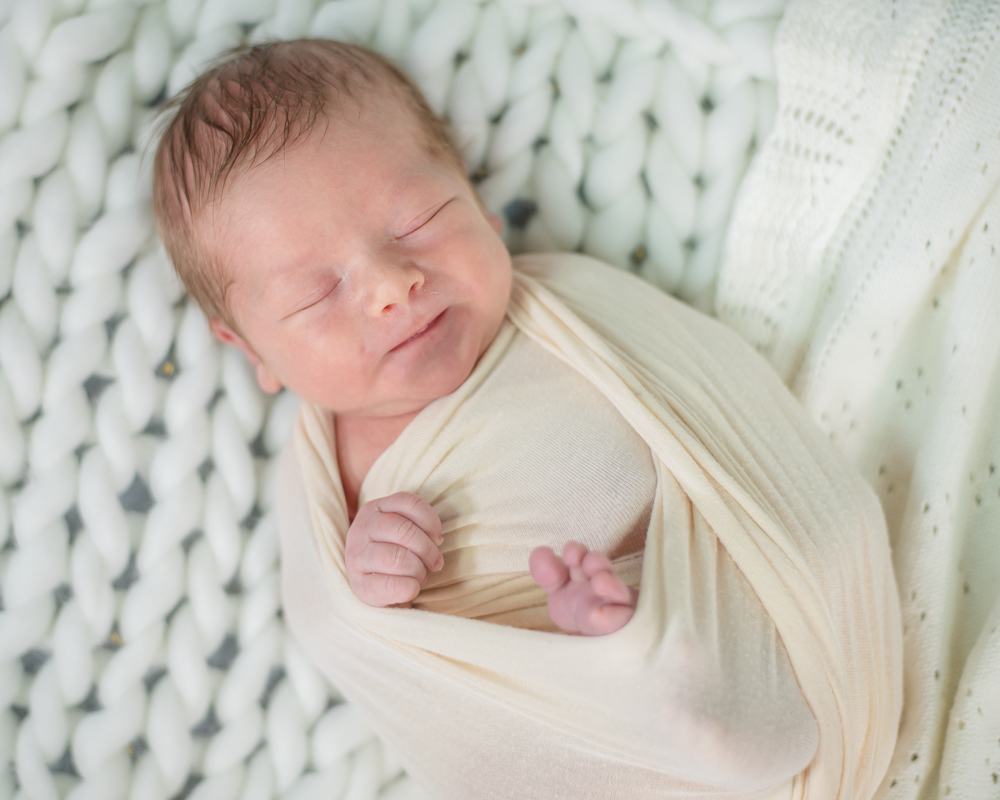 Baby Jacob smiles in wrap, newborn photographers Aspatria