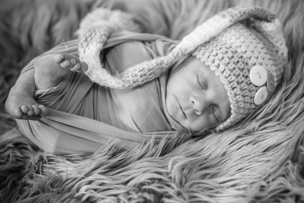 Baby wrapped in blanket with bobble hat, Cockermouth newborn photographers
